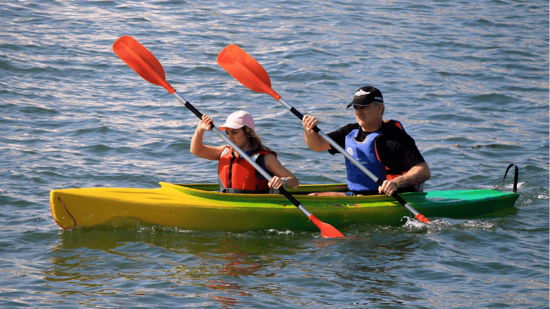 Man and woman kayaking together on a sunny day in Winter Park waters.