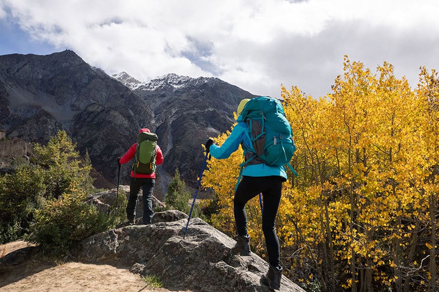 Two backpacking hikers on mountain with fall color change